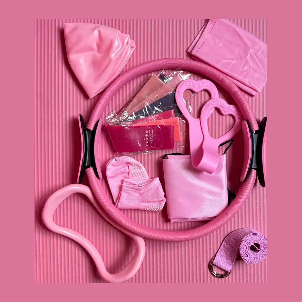 Pink pilates accessories flat lay on a pink mat