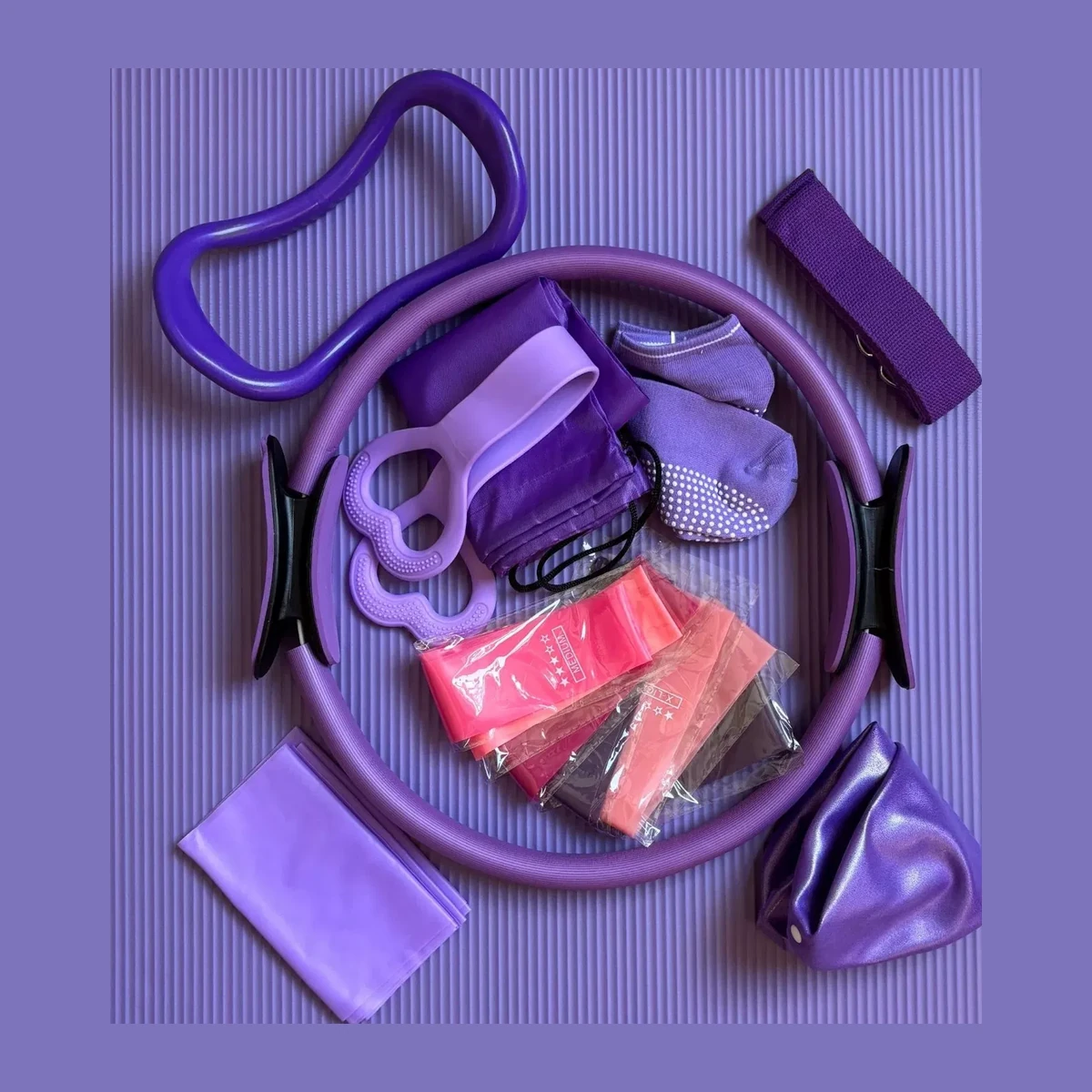 Purple pilates accessories flat lay on a purple mat