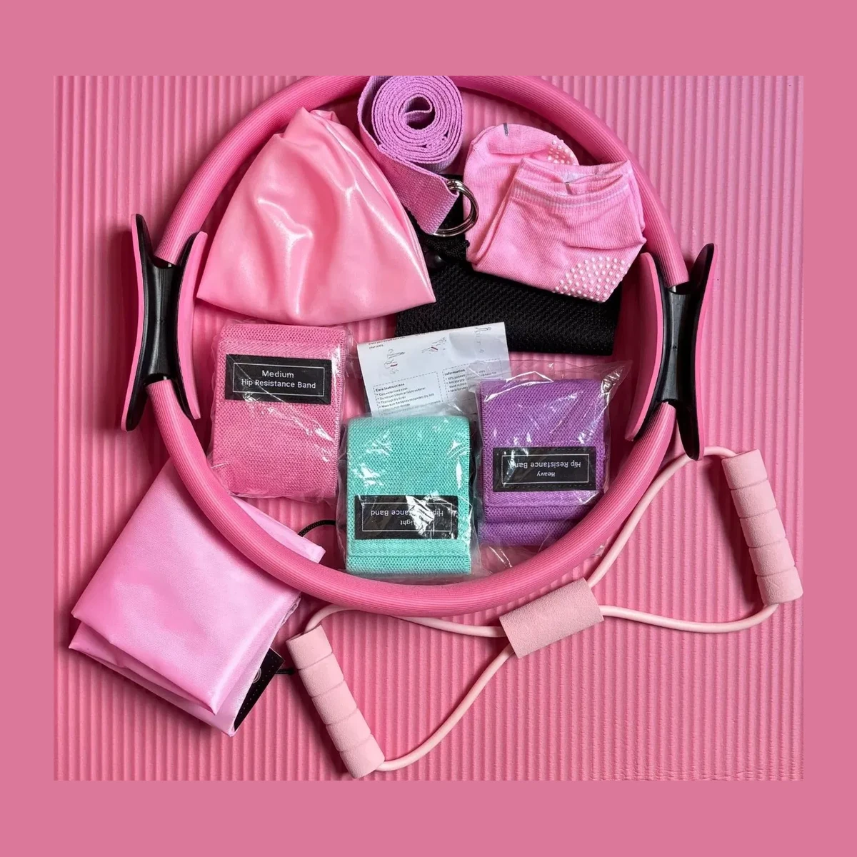 Pink pilates starter kit arranged on a pink mat